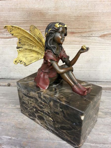 Bronzeelfe sitzend auf Marmorsockel